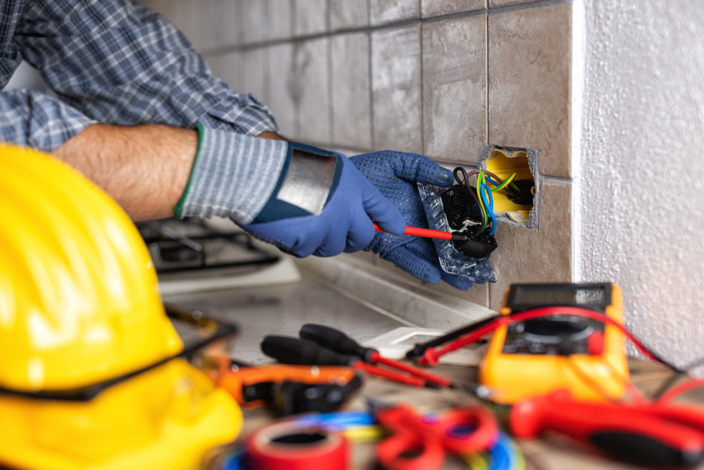 Electrician at work with screwdriver fixes the cable in the sockets of a residential electrical system